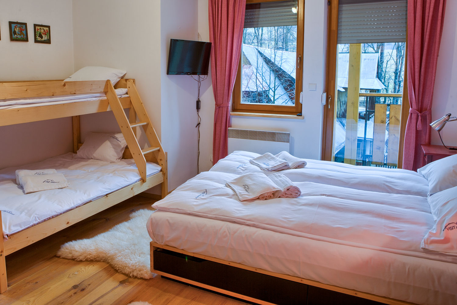 Podwójne łóżko oraz piętrowe łóżko w sypialni z balkonem